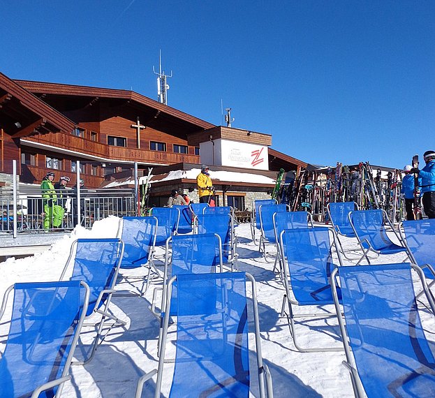 Tuxer Fernerhaus mit blauen Sonnenstühlen im Vordergrund