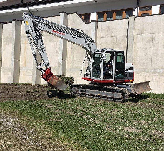 Bagger schaufelt Gras
